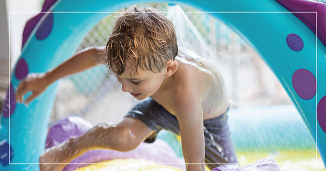 Kind auf Wasserspielinsel im Schwimmbad