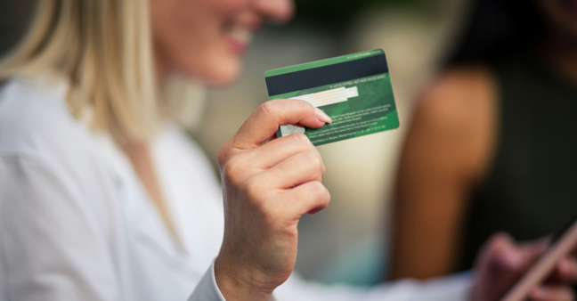 Frau hält Scheckkarte in der Hand