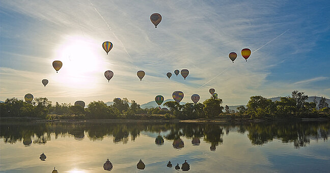 Heißluftballons über Seelandschaft